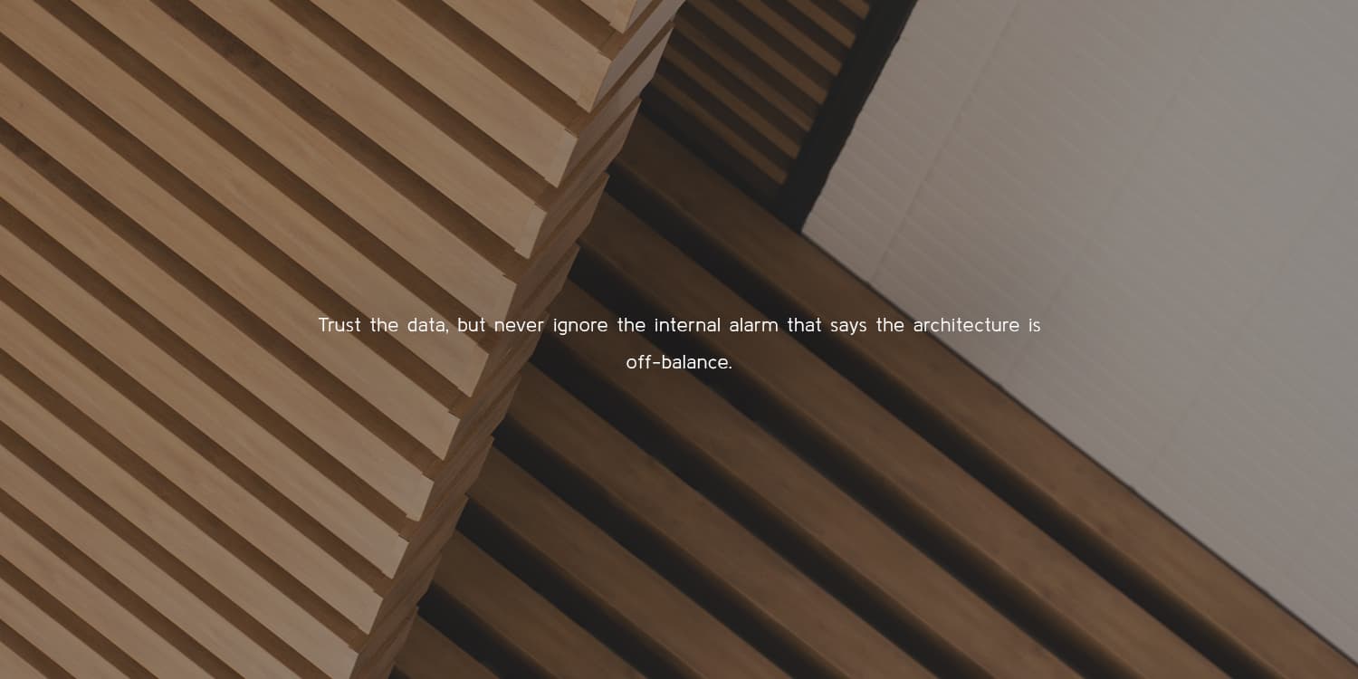 Architectural photo with overlay and text "Trust the data, but never ignore the internal alarm that says the architecture is off-balance."